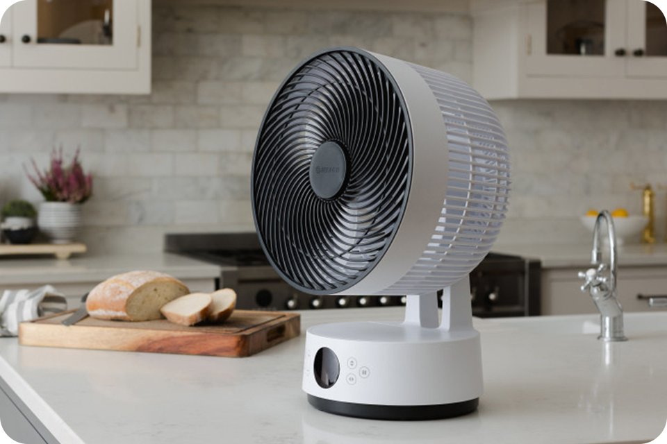 A white Meaco Sefte fan on a kitchen counter top with sourdough bread on the side.
